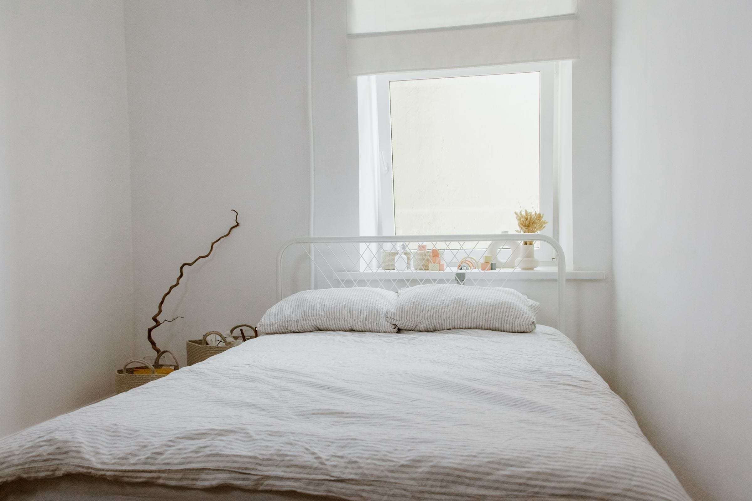 Chambre aux murs et au plafond repeints en blanc, lumière naturelle